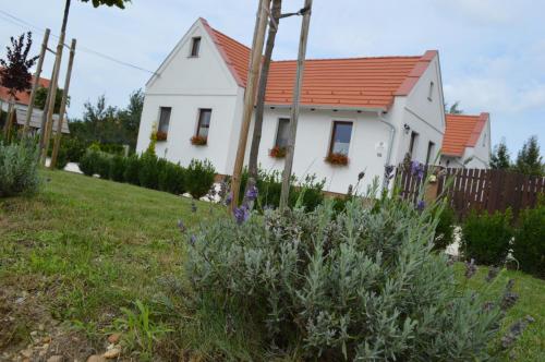 una pequeña casa blanca con techo naranja en Levendula Apartman en Hegykő