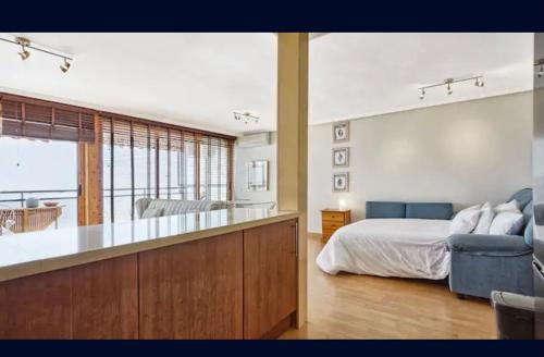 una camera con letto e una cucina con divano di GLP CAMPELLO BEACH a El Campello