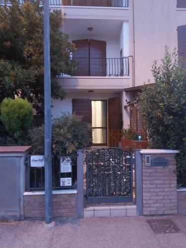 a white house with a gate and a balcony at CasaMG in Ravenna