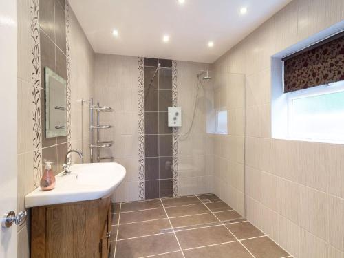 a bathroom with a sink and a shower at Three bedroomed house with a separate studio apartment by Severn Valley railway in Highley