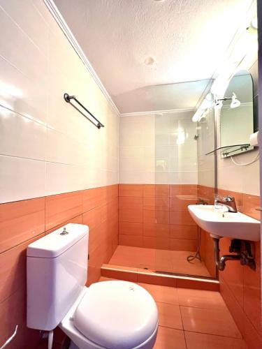 a bathroom with a toilet and a sink at Grand Pension in Néa Koróni