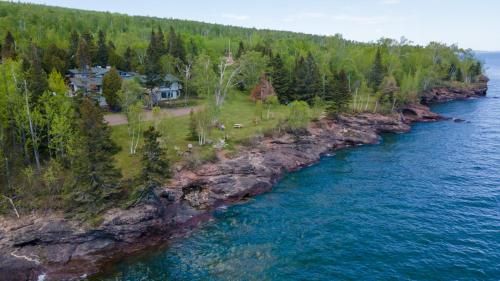 an aerial view of a house on the shore of a river at Thomsonite Inn on Lake Superior in Grand Marais