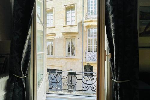T4 apartment in the heart of old Bordeaux close to all amenities في بوردو: نافذة مفتوحة مطلة على مبنى