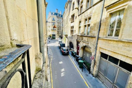 T4 apartment in the heart of old Bordeaux close to all amenities في بوردو: a car driving down a city street with buildings