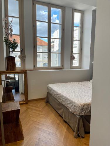 une chambre avec un lit et deux fenêtres dans l'établissement Superbe 40 m2 tout confort au cœur de Dijon, à Dijon
