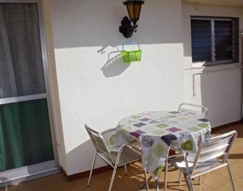 una mesa y sillas con una cesta verde en la pared en Apartament Sant Joan, en Sant Joan de Vilatorrada