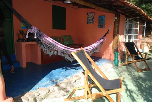a hammock hanging from the side of a house at Pousada Estância Rio Acima in Itamonte
