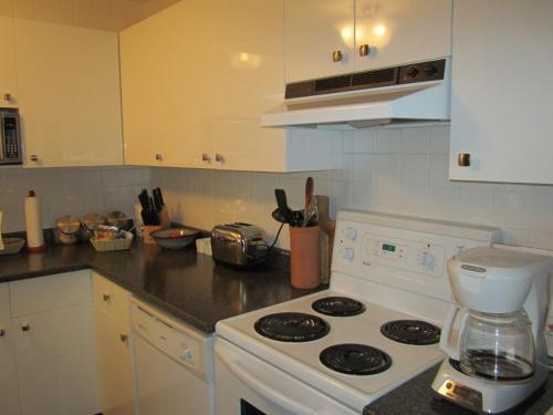 een keuken met een wit fornuis en een witte blender bij Heathergate Cottage and Suites in Victoria