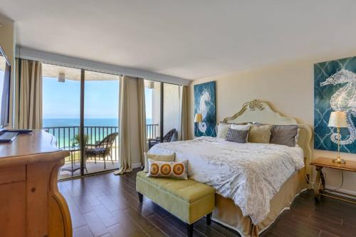 a bedroom with a bed and a balcony with the ocean at 1506 Lighthouse Towers in Clearwater Beach