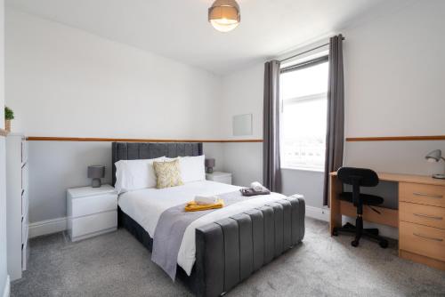 a bedroom with a bed and a desk and a window at Spacious 4BR, Parking, Near Centre, Accommodates 7 in Sheffield