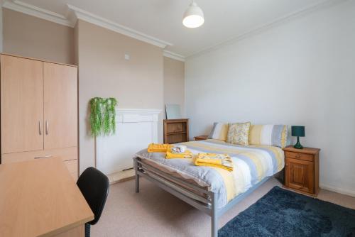 um quarto com uma cama, uma secretária e uma mesa em Spacious & Homely, 4 BR, Parking, Close to Centre em Sheffield
