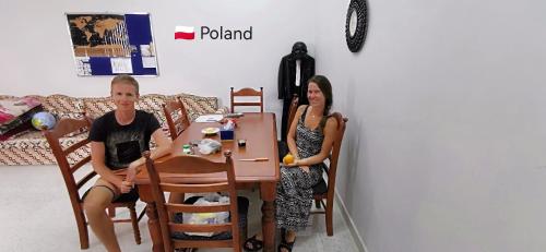 a man and a woman sitting at a table at 228Hostel in Al Ḩamrāʼ