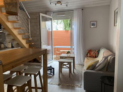 een woonkamer met een trap, een bank en een tafel bij Maison cosy, wifi terrasse, proche plage, gare, centre in Arcachon