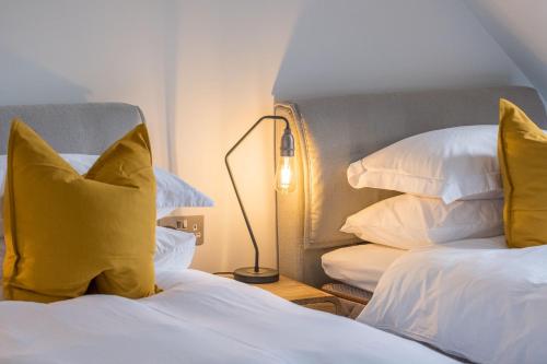 a bedroom with two beds with yellow pillows and a lamp at The Arran, St Andrews in St. Andrews