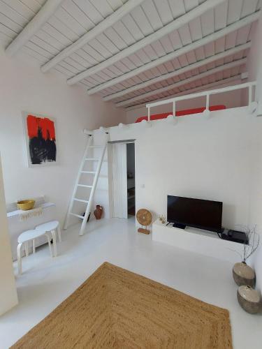 a white room with a loft bed and a tv at Casa Coral in São Marcos do Campo