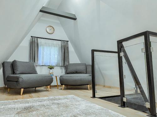 a living room with two chairs and a mirror at Tiszaparti Meseház in Tiszalök