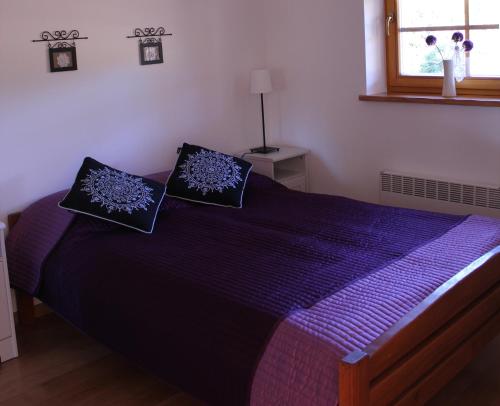 sypialnia z fioletowym łóżkiem z 2 poduszkami w obiekcie Apartament Rysulówka 180 w mieście Kościelisko
