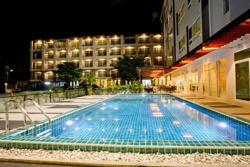 uma piscina em frente a um edifício à noite em Sinsuvarn Airport Suite Hotel SHA Extra Plus Certified B5040 em Lat Krabang