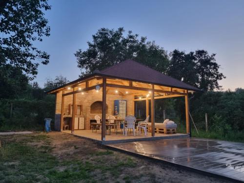 a pavilion with a table and chairs on a patio at HOOPOVO HOUSE Fruška gora in Irig