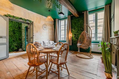 a dining room with a table and chairs at Jungle - 4 pers- Sauna- Vidéoprojecteur - Terrasse in Libourne