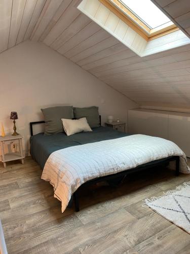 een slaapkamer met een groot bed op zolder bij Maison cosy, wifi terrasse, proche plage, gare, centre in Arcachon