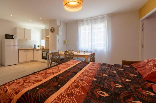 une chambre avec un grand lit et une cuisine dans l'établissement LOC TROTTEUR LE SAFRAN F2 Grand confort, gare SNCF de Lourdes, à Lourdes