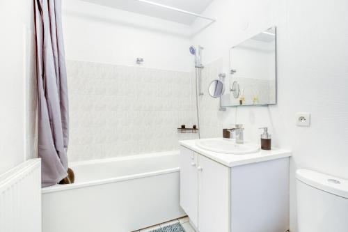 een witte badkamer met een wastafel en een douche bij Charmant studio au pied du métro (ligne 8) in Créteil
