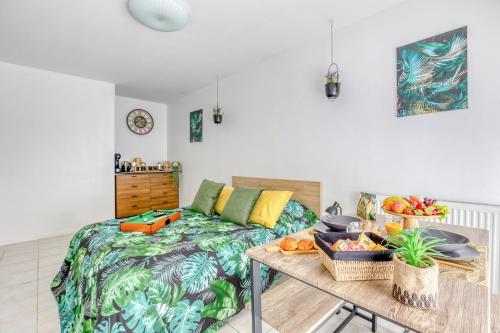 een slaapkamer met een bed en een tafel met eten erop bij Charmant studio au pied du métro (ligne 8) in Créteil