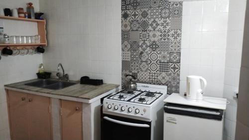 una cocina con estufa y fregadero en Depto central, en Tandil