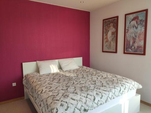 a bedroom with a large bed with purple walls at Spacious 110 M2 Apartment With Forest View in Zapyškis