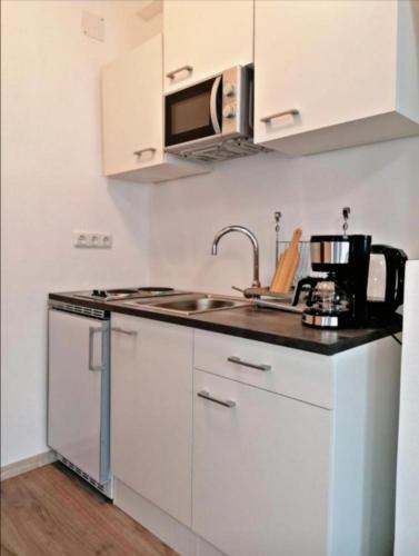 a white kitchen with a sink and a microwave at Casa Cristina in Untertweng