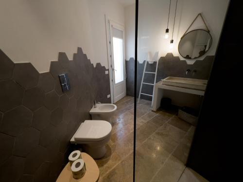 a bathroom with a toilet and a sink at meridiano12 in Favignana