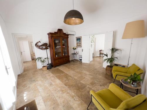 a living room with yellow chairs and a couch at meridiano12 in Favignana