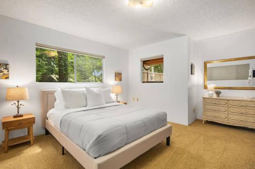 ein weißes Schlafzimmer mit einem großen Bett und einer Kommode in der Unterkunft Coastal Cottage, 4 Large Decks, Close to Beach in Blaine