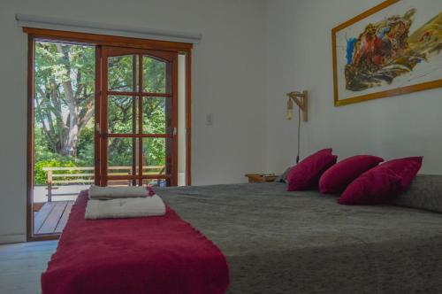 a bedroom with a large bed with red pillows at Excelente casa en Concepción del Uruguay LA CHINA in Concepción del Uruguay