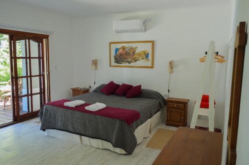 a bedroom with a bed with red pillows at Excelente casa en Concepción del Uruguay LA CHINA in Concepción del Uruguay