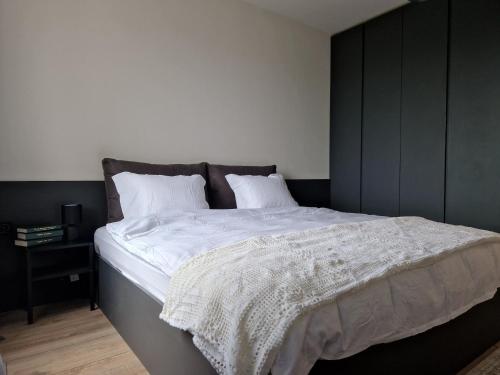 um quarto com uma cama grande e lençóis brancos em Apartment Enya em Burgas