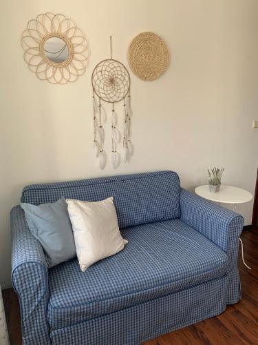 a blue couch in a living room with a mirror at Pokoje Pinokio in Darłowo