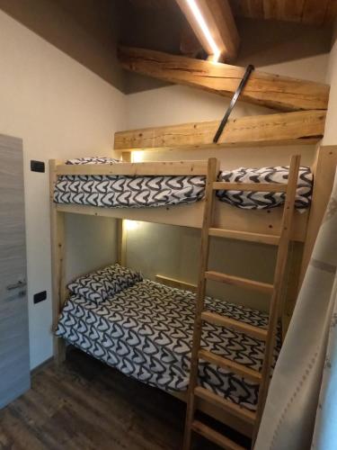 two bunk beds in a room with a ladder at Appartamenti il bersaio Alloggio 3 in Sambuco