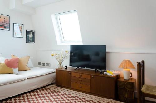 - un salon avec une télévision à écran plat sur une commode en bois dans l'établissement Relaxing Retreat with Terrace & Sea Views - Sleeps 4, à Kent
