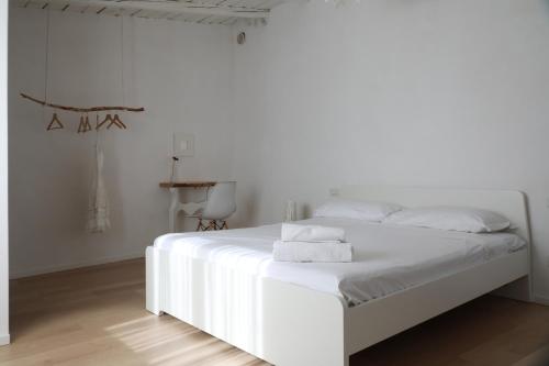 a white bedroom with a white bed with white sheets at Casa Lupita in Favara