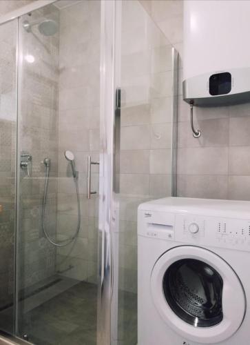 a washing machine in a bathroom with a shower at Apartman Aria in Dugi Rat