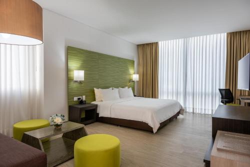 Holiday Inn Express - Cartagena Bocagrande, an IHG Hotel في كارتاهينا دي اندياس: فندق غرفه بسرير وصاله