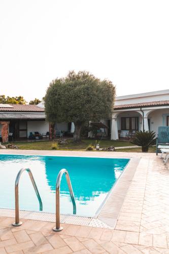 a swimming pool with two metal rails next to a house at Agriturismo Irghitula in Posada