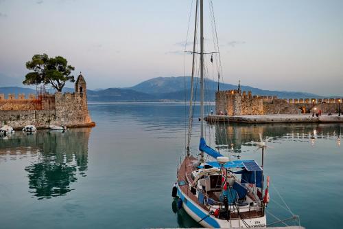 a boat sitting in the water next to a castle at Castellmare in Nafpaktos