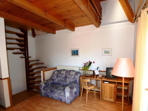a living room with a chair and a desk with a computer at Bakony Hotel in Bakonybél