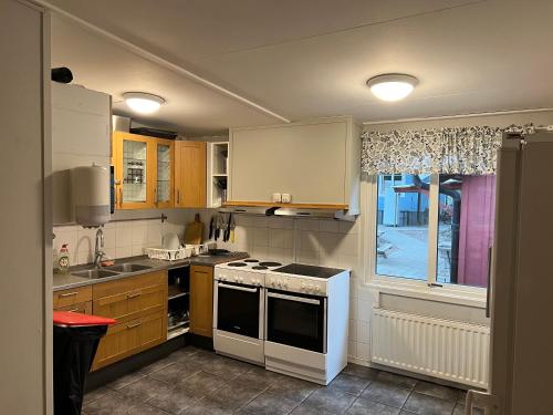 a kitchen with a stove and a sink and a window at Beach House Ystad in Ystad