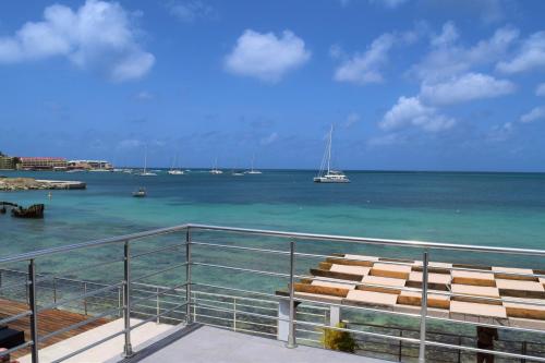 a balcony with a view of the ocean and boats at Tradewinds Apartments Simpson Bay in Simpson Bay