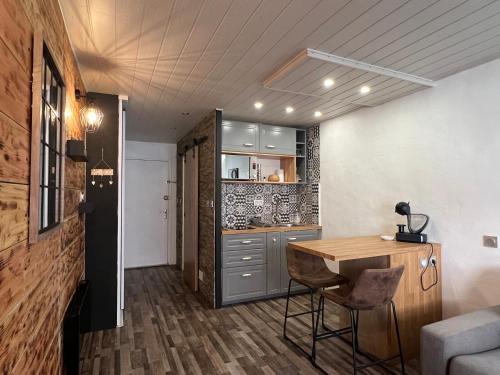 une cuisine avec une table en bois et un comptoir dans l'établissement LE NICHOIR, à Cauterets
