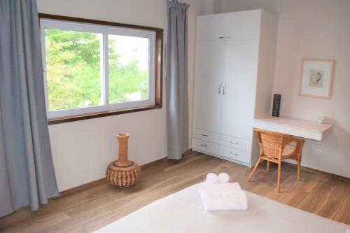 a bedroom with a bed and a window and a desk at Tradewinds Apartments Simpson Bay in Simpson Bay